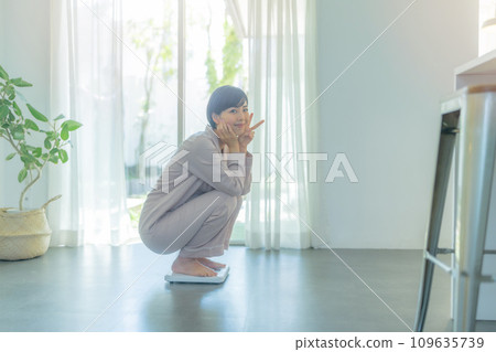 A woman in her 20s weighing herself 109635739