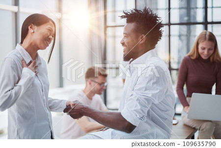 Business Handshake - business people shaking hands. Handshake between business man and woman indoors. 109635790