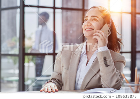 Portrait of smiling female who is talking by phone 109635873