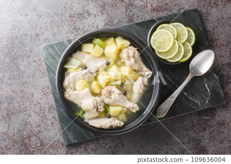 Chicken souse is a Bahamian soup consisting of clear broth where the meat and the vegetables are boiled down in the juice of fresh citrus closeup on the plate. Horizontal top view Chicken souse is a Bahamian soup consisting of clear broth where the meat and the vegetables are boiled down in the juice of fresh citrus closeup on the plate. Horizontal top view 109636004