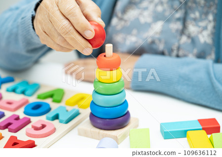 Alzheimer disease AD, Asian elderly woman patient suffering from dementia learn practical motor skills rehabilitation. 109636112