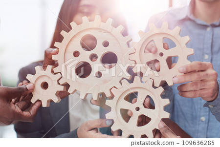 Office worker holding cog wheel as unity and teamwork in corporate workplace concept. Office worker holding cog wheel as unity and teamwork in corporate workplace concept. 109636285