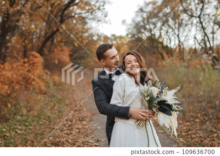 happy bride and groom enjoying romantic moments outside in autumn happy bride and groom enjoying romantic moments outside in autumn 109636700