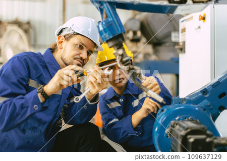 Engineer team worker fix service replace broken part of automatic industry robotic welding arm. staff repair maintenance robot welding machine. Engineer team worker fix service replace broken part of automatic industry robotic welding arm. staff repair maintenance robot welding machine. 109637129
