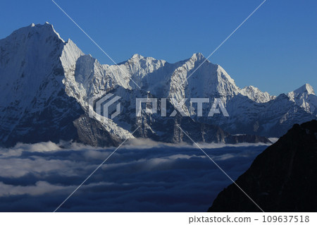 Snow covered high mountain Kusum Kanguru and sea of fog seen from Gokyo Ri, Nepal. 109637518