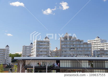 郊區通勤小鎮,公寓大樓在藍天的襯托下閃閃發光 郊區通勤小鎮,公寓大樓在藍天的襯托下閃閃發光 109637555