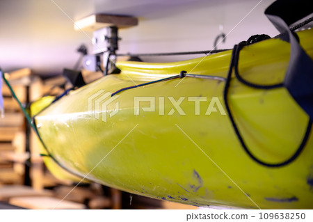 Selective focus on the side of a kayak that has used a Hoist and pulley system to store on the ceiling of a garage. Selective focus on the side of a kayak that has used a Hoist and pulley system to store on the ceiling of a garage. 109638250