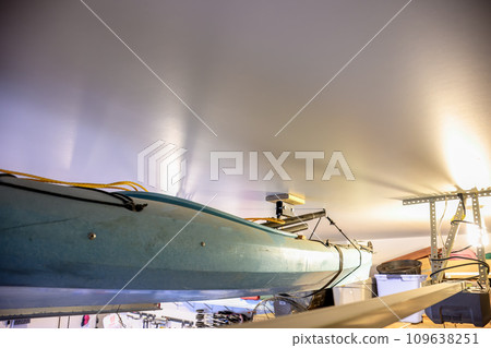 Selective focus on the side of a kayak that has used a Hoist and pulley system to store on the ceiling of a garage. Selective focus on the side of a kayak that has used a Hoist and pulley system to store on the ceiling of a garage. 109638251