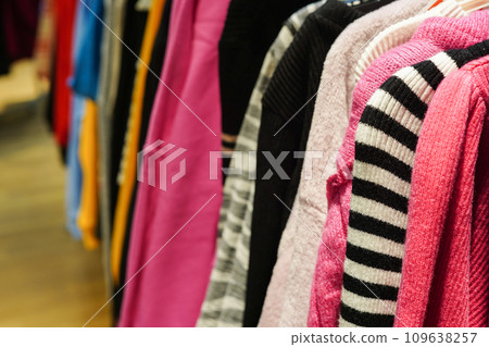 Stylish colorful clothes on hangers in the store Stylish colorful clothes on hangers in the store 109638257