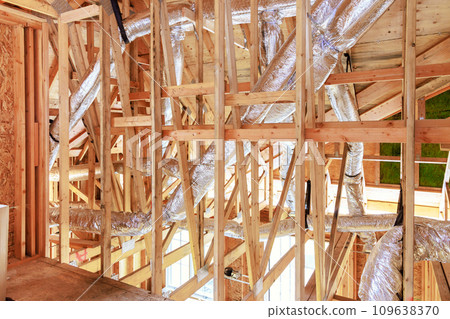Wooden framing of new construction home with beams is attached to framework 109638370