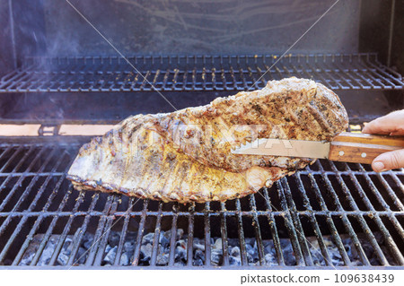 In flaming BBQ grill, marinated pork ribs are being roasted 109638439