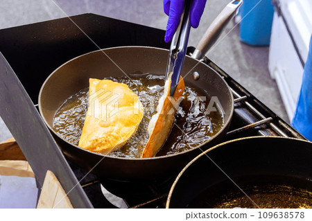 Fried cheburek with oil, traditional Crimean Tatar food dish Fried cheburek with oil, traditional Crimean Tatar food dish 109638578