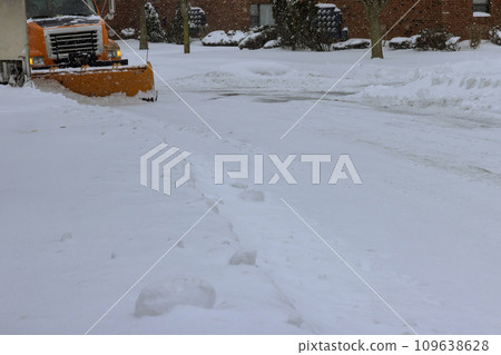 After heavy snowstorm, snowstorm snowplow trucks remove snow from road at residential area 109638628