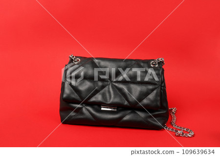 Black female handbag with chain on red background Black female handbag with chain on red background 109639634