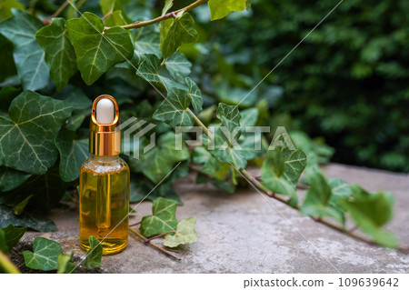 Dropper golden glass bottle with cosmetic oil or serum on nature background with copy space Dropper golden glass bottle with cosmetic oil or serum on nature background with copy space 109639642