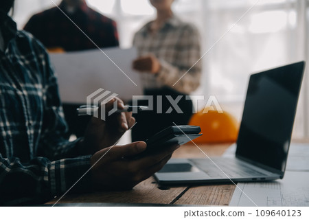 Two business man construction site engineer. Engineering objects on workplace with partners interacting on background Two business man construction site engineer. Engineering objects on workplace with partners interacting on background 109640123