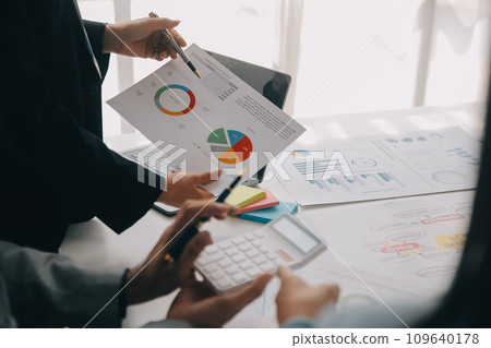 Financial analysts analyze business financial reports on a digital tablet planning investment project during a discussion at a meeting of corporate showing the results of their successful teamwork. 109640178