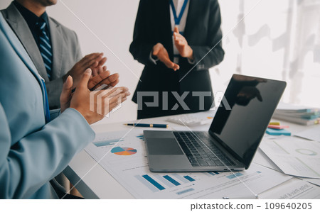 Financial analysts analyze business financial reports on a digital tablet planning investment project during a discussion at a meeting of corporate showing the results of their successful teamwork. 109640205