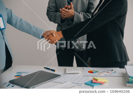 Financial analysts analyze business financial reports on a digital tablet planning investment project during a discussion at a meeting of corporate showing the results of their successful teamwork. 109640206