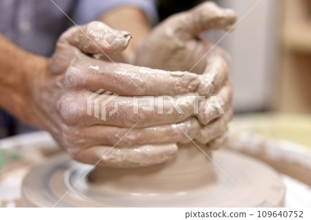 male hands making ceramic cup on pottery wheel, Close-up 109640752
