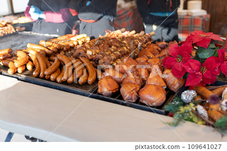 Grilled sausages in street market in a medieval fair in Poland. Sausages and pork ready to eat. Festival of street food and meat. Selling traditional hot food at the Christmas Fair Grilled sausages in street market in a medieval fair in Poland. Sausages and pork ready to eat. Festival of street food and meat. Selling traditional hot food at the Christmas Fair 109641027