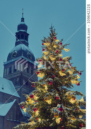 Decorated Christmas tree at the Dome Square in old Riga city, Riga Cathedral tower on background. Riga, Latvia. Decorated Christmas tree at the Dome Square in old Riga city, Riga Cathedral tower on background. Riga, Latvia. 109642228