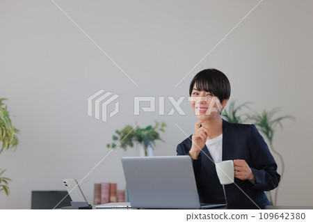 Business woman smiling with a coffee cup 1 Business woman smiling with a coffee cup 1 109642380