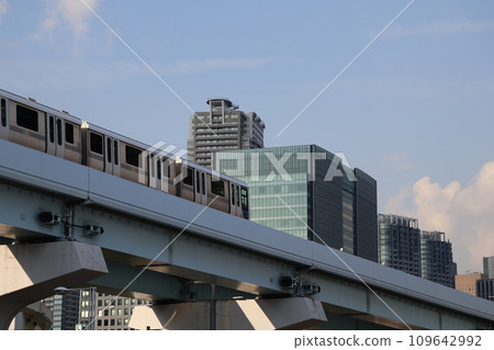 Urban cityscape with monorail going between blue sky, clouds and skyscrapers Urban cityscape with monorail going between blue sky, clouds and skyscrapers 109642992