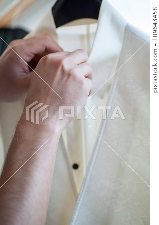 Dressing in Detail: Fastening the Groom's Attire 109643458
