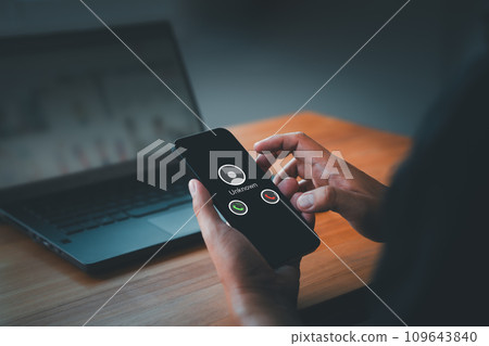 Man answering the incoming call. The phone call was from an unknown number. Call center gang or stranger. Hoax person with a fake identity. Concept of scam, fraud with a smartphone from the criminal.. 109643840