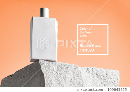 Skincare product bottle on piece of stone against peach fuzz color background 109643855