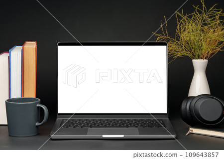 Laptop with blank screen on table against black background Laptop with blank screen on table against black background 109643857