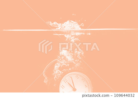 Alarm clock falling into the water photo toned in peach fuzz color of the year 2024 109644032