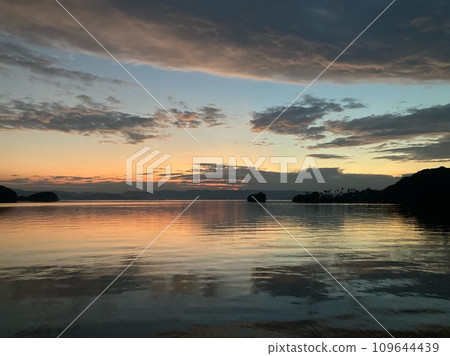 Sunset reflecting on the calm water surface 109644439