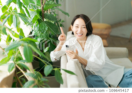 中年婦女在沙發上操作智慧型手機 109645417