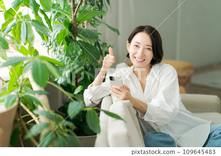 中年婦女在沙發上操作智慧型手機 中年婦女在沙發上操作智慧型手機 109645483