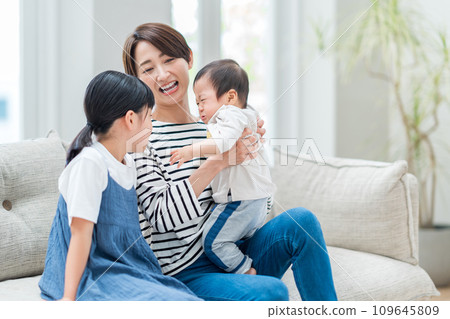 A mother and daughter comfort a crying boy. 109645809