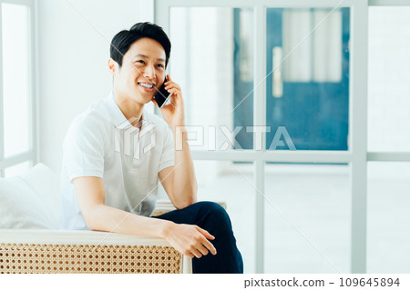 A man operating a smartphone. 109645894