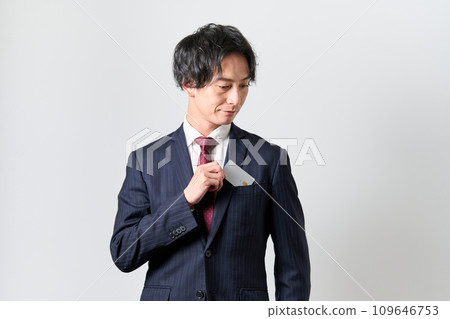 一名男子從胸前口袋掏出一張信用卡 一名男子從胸前口袋掏出一張信用卡 109646753