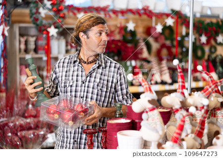 Man customer in store are choosing Christmas decorations for celebrating Christmas. Man customer in store are choosing Christmas decorations for celebrating Christmas. 109647273