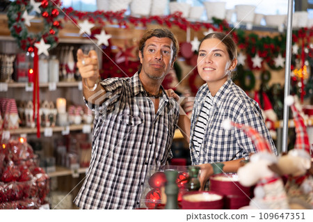 Couple choosing christmas decorations in store Couple choosing christmas decorations in store 109647351