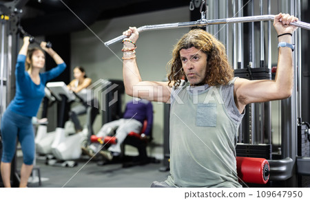 Caucasian man is engaged in a simulator for development of back muscles 109647950