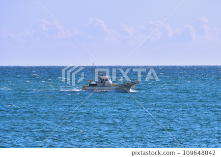A fishing boat sailing through the blue sea A fishing boat sailing through the blue sea 109648042