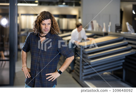 Confident man picking new bathroom wall furnishing materials in hardware store 109648092