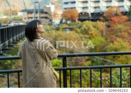 A woman standing in the autumn leaves 109648283