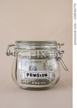Glass jar full of American currency dollars cash banknote with text PENSION. Preparation saving money. Moderate consumption and economy 109648770