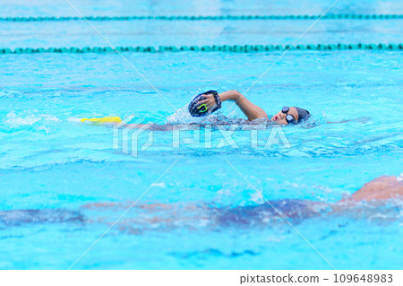 child swimmer swim in swimming pool. Water sports training and competition, learning to swim classes for children 109648983