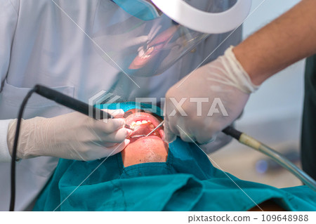 doctor cleaning the teeth patient with ultrasonic tool doctor cleaning the teeth patient with ultrasonic tool 109648988