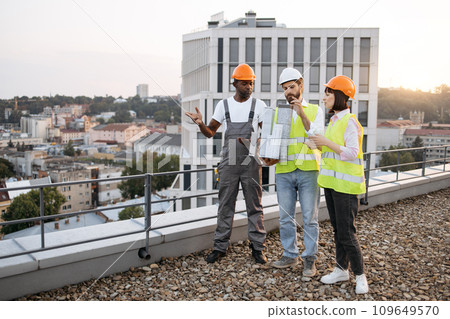 Team looking at small model of residential building outdoors 109649570