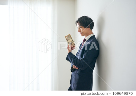 A man holding a wad of bills in his hand 109649870